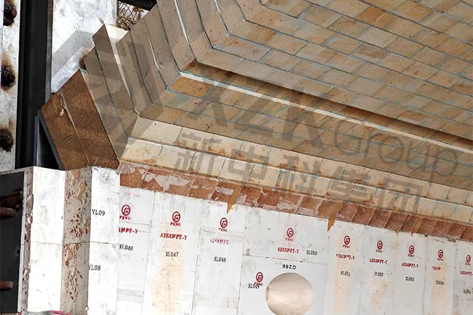 Crown corner (springing) with the insulating back-up courses already laid. This transition decides how the crown and the side wall move against each o